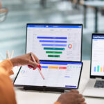 Une professionnelle examine le suivi des demandes commerciales sur ordinateur.