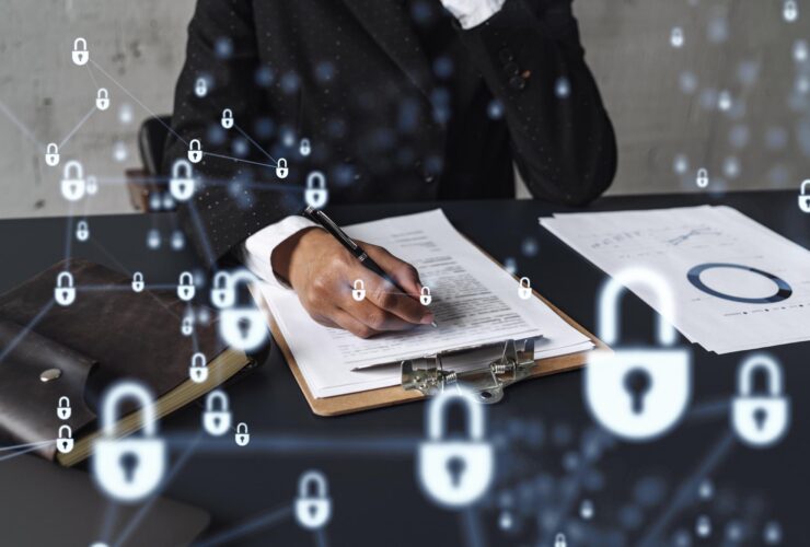 Dirigeante de cabinet signant un document devant des symboles de cybersécurité