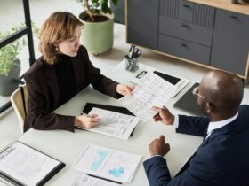 Deux personnes examinent des documents financiers autour d’une table