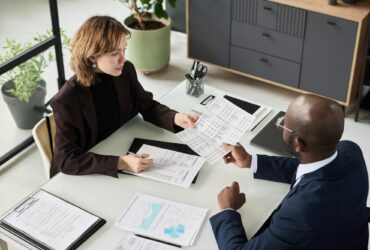 Deux personnes examinent des documents financiers autour d’une table